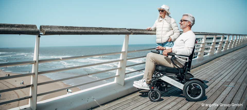 Älteres Paar ist mit Rollstuhl auf Reisen